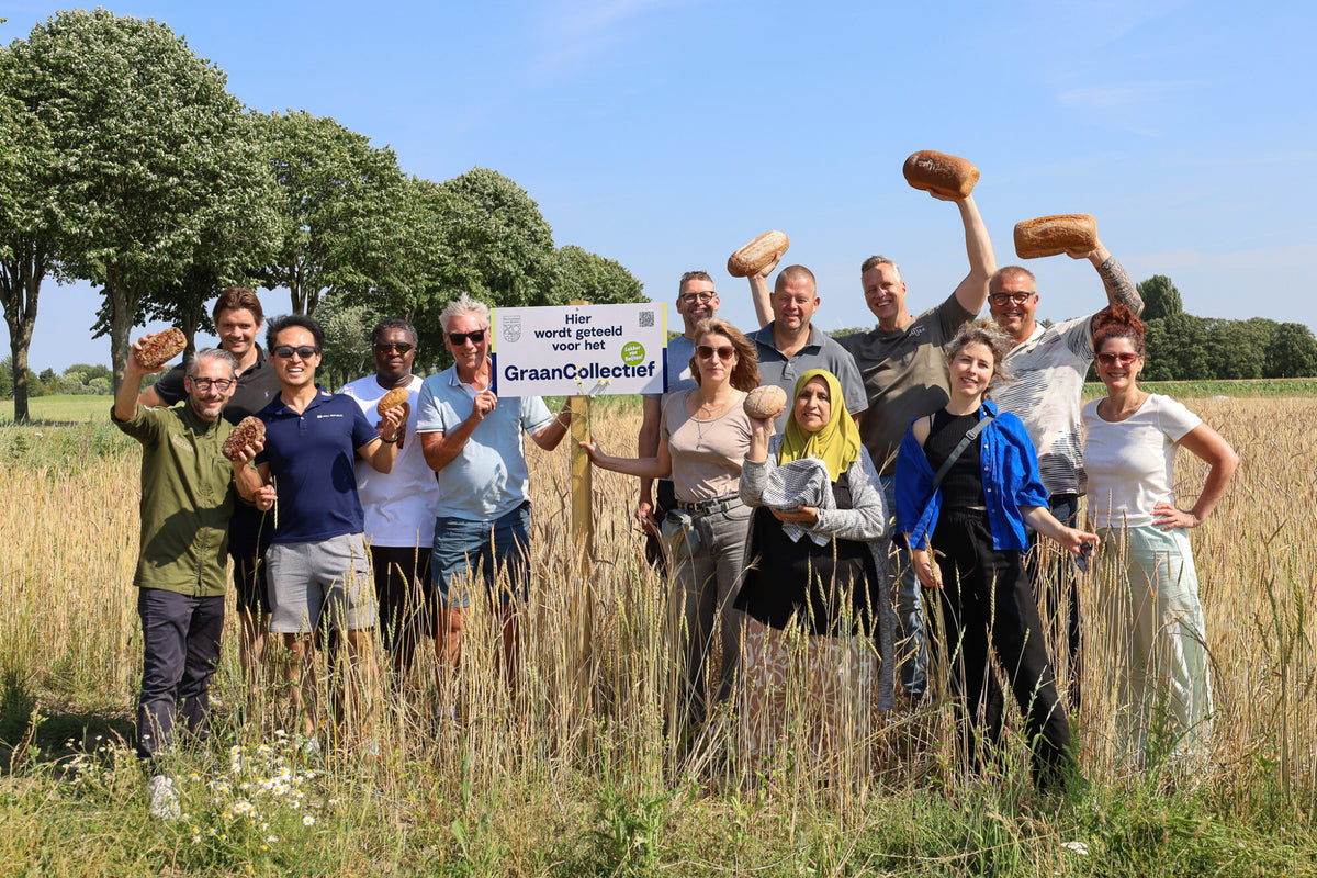 Farmers and bakers of GraanCollectief holding bread in a regenerative grain field near Rotterdam